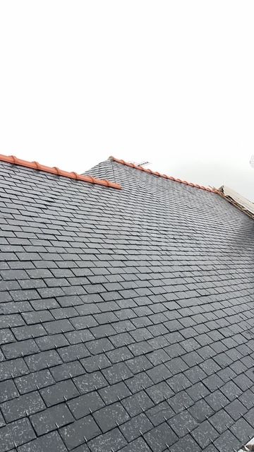 Détail d'une toiture en ardoise avec faîtage en terre cuite